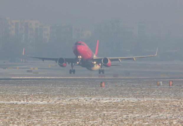 Startujący Wizzair i w tle, tonący w smogu Ursynów, na codzień dosyć widoczny z drugiej strony Lotniska.